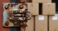 Rusty metal latch secures a shipping container with cardboard boxes in the background Royalty Free Stock Photo