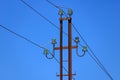 Rusty metal power line support with wires and glass insulators close-up against the blue sky Royalty Free Stock Photo