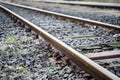 Rusty metal railway tracks and brackets in a ballast bed, diagonal, selected focus, narrow depth of field Royalty Free Stock Photo