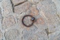 A rusty metal ring is sitting on a stone surface. The ring is old and worn, and it is a piece of jewelry. The stone surface is Royalty Free Stock Photo