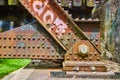 Rusty metal rivets on railroad bridge side view and pink graffiti with corroding blue metal Royalty Free Stock Photo