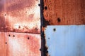 Rusty metal sheets with rivets cover corner of old shed Royalty Free Stock Photo