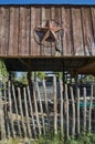 The rusty metal star of Texas hung on the outside wooden walls of an old ramshackle barn.