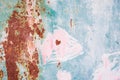 Rusty metal surface with pink, green, blue, turquoise paint flaking. Small heart. Old cracked paint pattern, cracking texture