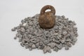 Rusty metal weight placed on crushed granite stones, concept of durability, stability, and strong construction base Royalty Free Stock Photo
