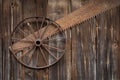 Rusty metal wheel hangs on the wall from old boards Royalty Free Stock Photo