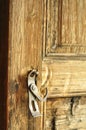 Rusty metallic door handle, latch or lock on an old door made of rustic wood. Entrance to a rural cabin in Sweden with vintage, Royalty Free Stock Photo