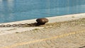 Rusty mooring bollard with an iron chain on the harbor pier Italy, Europe Royalty Free Stock Photo