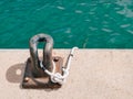 Rusty mooring bollard with a rope on a concrete pier Royalty Free Stock Photo