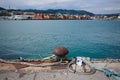 Rusty mooring bollard with ropes and chain on pier in port of La Spezia, Italy Royalty Free Stock Photo