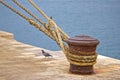 Rusty mooring bollard with ship ropes Royalty Free Stock Photo