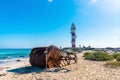 Rusty nautical buoy with lighthouse at seashore against sky Royalty Free Stock Photo