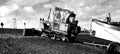 Fishing boat being pulled out of the sea by rusty bulldozer tractor on weybournes norfolk beach