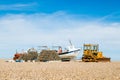 Old rusty bulldozer tractoron a pebble beach with lobster pots and nets Royalty Free Stock Photo