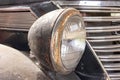 A rusty old car front headlight close up