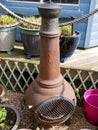 Rusty chimenea in garden with plant pots