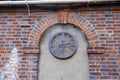 Rusty old clock face under a brick arch Royalty Free Stock Photo