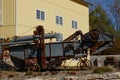 Rusty old combine sits in front of a new barn