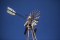 Rusty old farm windmill against blue sky