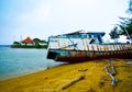 Rusty old fishing boat ship on the quiet yellow sandy beach in the fresh morning sunrise air Royalty Free Stock Photo