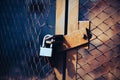 A rusty old gate with a torn metal grid is closed by a strong padlock. Closed territory Royalty Free Stock Photo