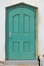 Rusty old green metal door in a white plaster wall Royalty Free Stock Photo