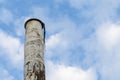 Rusty old iron chimney on blue sky background