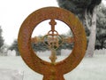 Rusty old iron circle with ornate cross headstone