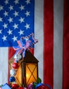 A rusty old lantern decorated with red, white and blue USA patriotic stars and stripes ribbons