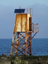 Rusty old light house beacon at harbour entrance