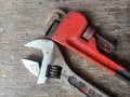 Rusty Old Pipe Wrench and Adjustable Wrench on Wood texture background Royalty Free Stock Photo