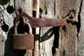 Rusty old steel padlock hanging on the wooden door. Retro tones processing Royalty Free Stock Photo