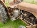 A rusty old tractor sitting in a grass area in England Royalty Free Stock Photo