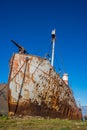 Rusty old whaler beached on grassy shore