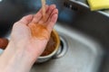 Rusty orange water flows from the kitchen faucet onto a man& x27;s hand Royalty Free Stock Photo