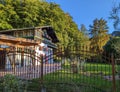 Rusty ornate fence with spikes in front of a typical Bavarian alpine house