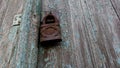 Rusty padlock against the background of old wood texture, peeling paint