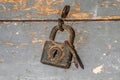 Rusty padlock closing an old wooden toolbox, timeworn paint