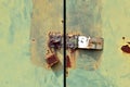 rusty padlock with hasp on grunge green metal door of cabinet under sunlight Royalty Free Stock Photo