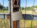 Rusty padlock locked on metal grid fence background Royalty Free Stock Photo