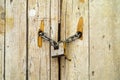 Rusty padlock locking old wooden door with a chain