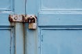 Rusty padlock on old painted wooden door