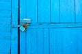 The rusty padlock on old wooden gate