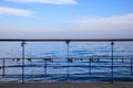 Rusty padlocks has been locked on a peeled railing of platform. Blue sky and sea background. Royalty Free Stock Photo