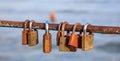 Rusty padlocks has been locked on a peeled railing. Blurred background, close up view with details.