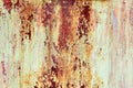 Rusty painted metal texture. Old iron background painted in yellow with rust. Weathered metal wall surface with cracked paint Royalty Free Stock Photo