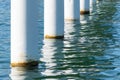 Rusty pier posts in salt sea water. White columns diagonal. Pillars mount for bridge. Sunny weather Royalty Free Stock Photo