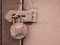 Rusty pink padlock hanging on the wooden door. Rustic, retro detachable lock Royalty Free Stock Photo