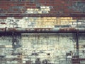 A rusty pipe is leaning against a brick wall Royalty Free Stock Photo
