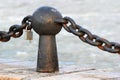 Rusty post of decorative metal fence with chain and padlock